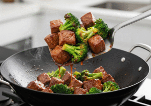 Cooked-beef-and-broccoli-being-tossed-together-in-a-wok-with-a-thick-glossy-and-delicious-stir-fry-sauce.
